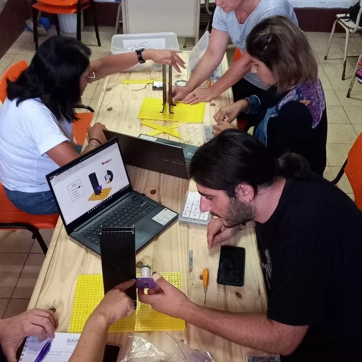 Docentes trabajando con kits de robótica en una capacitación de IABOT