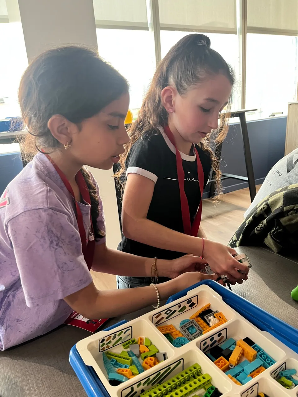 Dos participantes construyen un robot con piezas LEGO